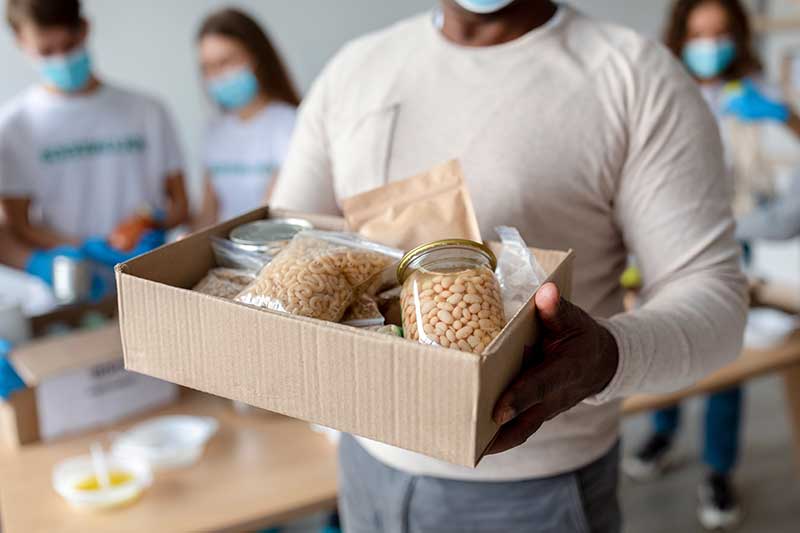 man-holding-box-with-donations-food